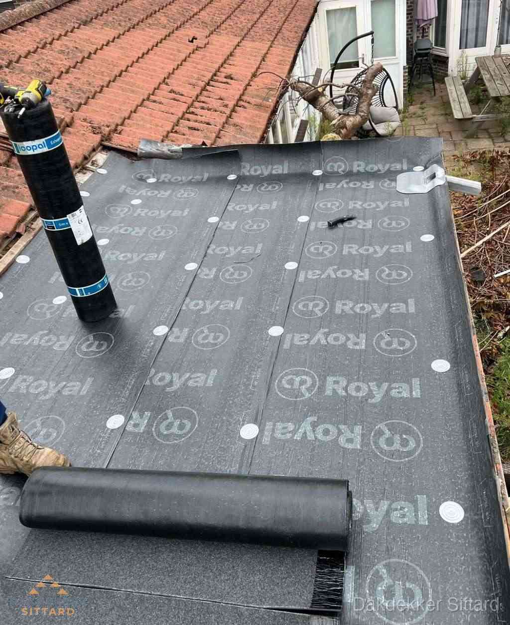 Plat dak met nieuwe bitumen dakbedekking en brandgereedschap in Sittard