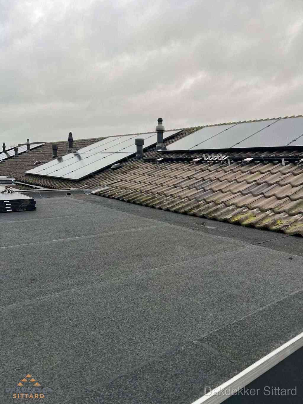 Plat dak inspectie met bitumen bedekking naast schuin pannendak in Sittard