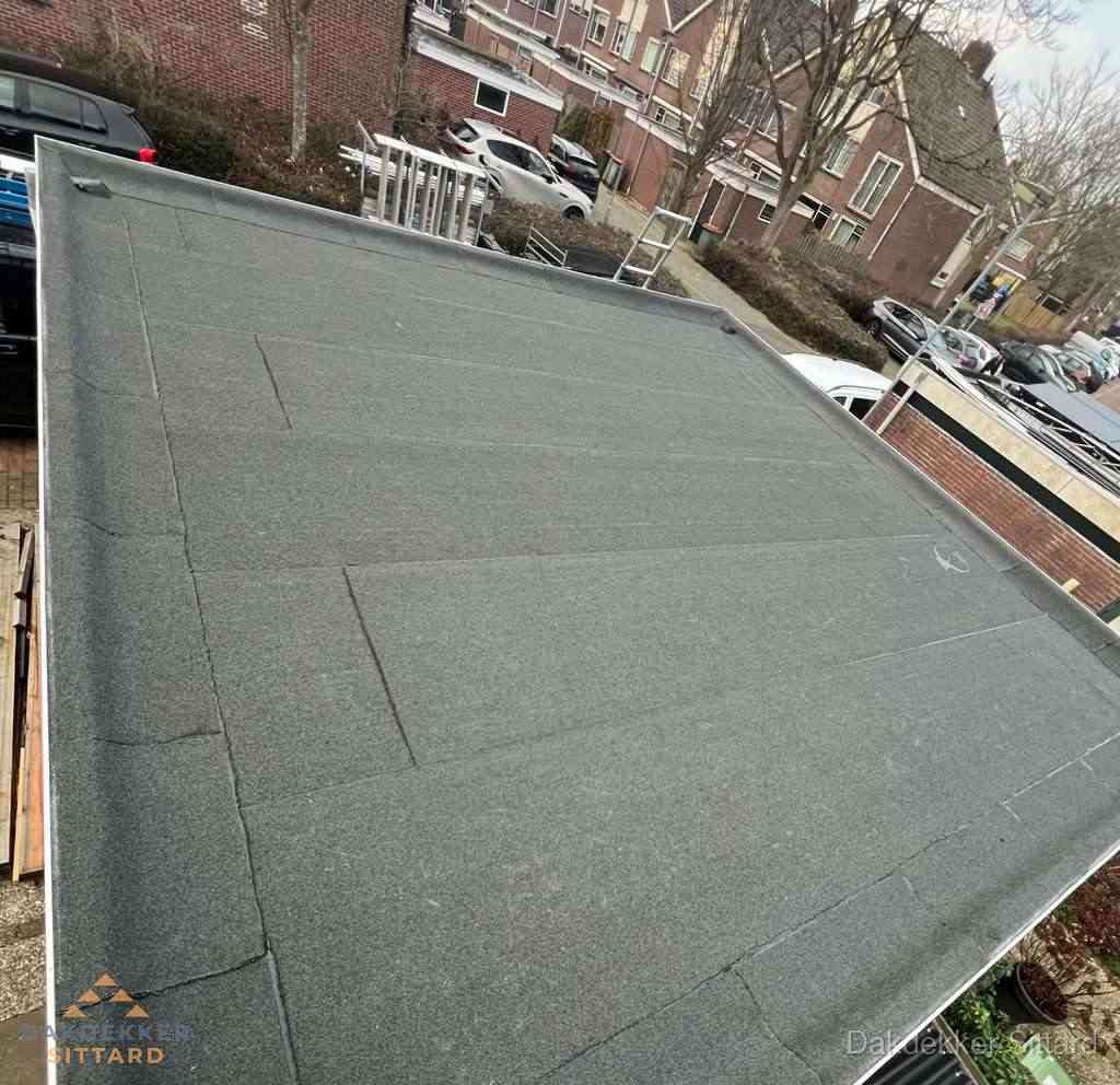 Nieuwe bitumen dakbedekking op plat dak van garage in Sittard