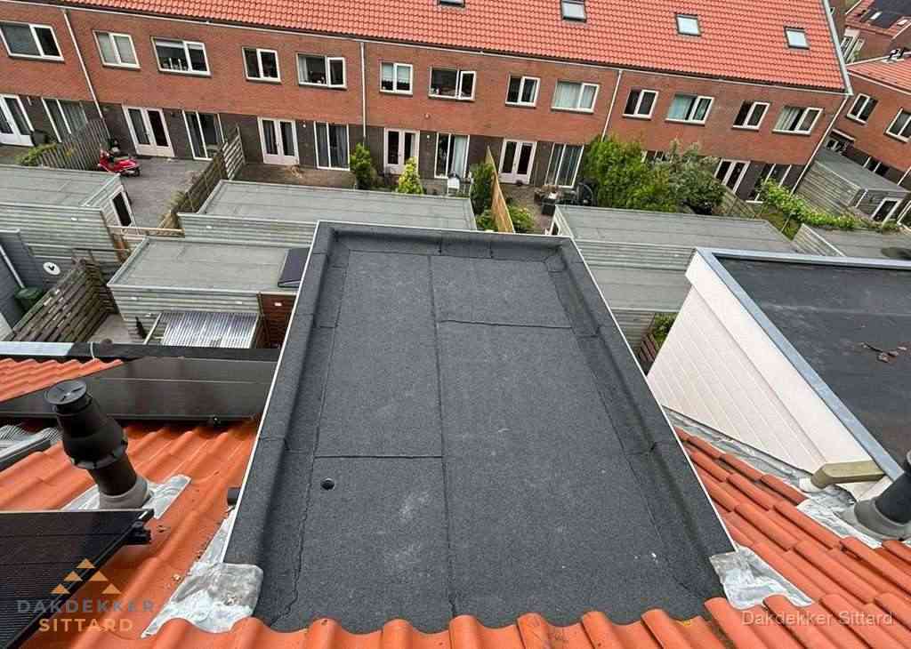 Plat dak met bitumen bedekking naast dakkapel in Sittard