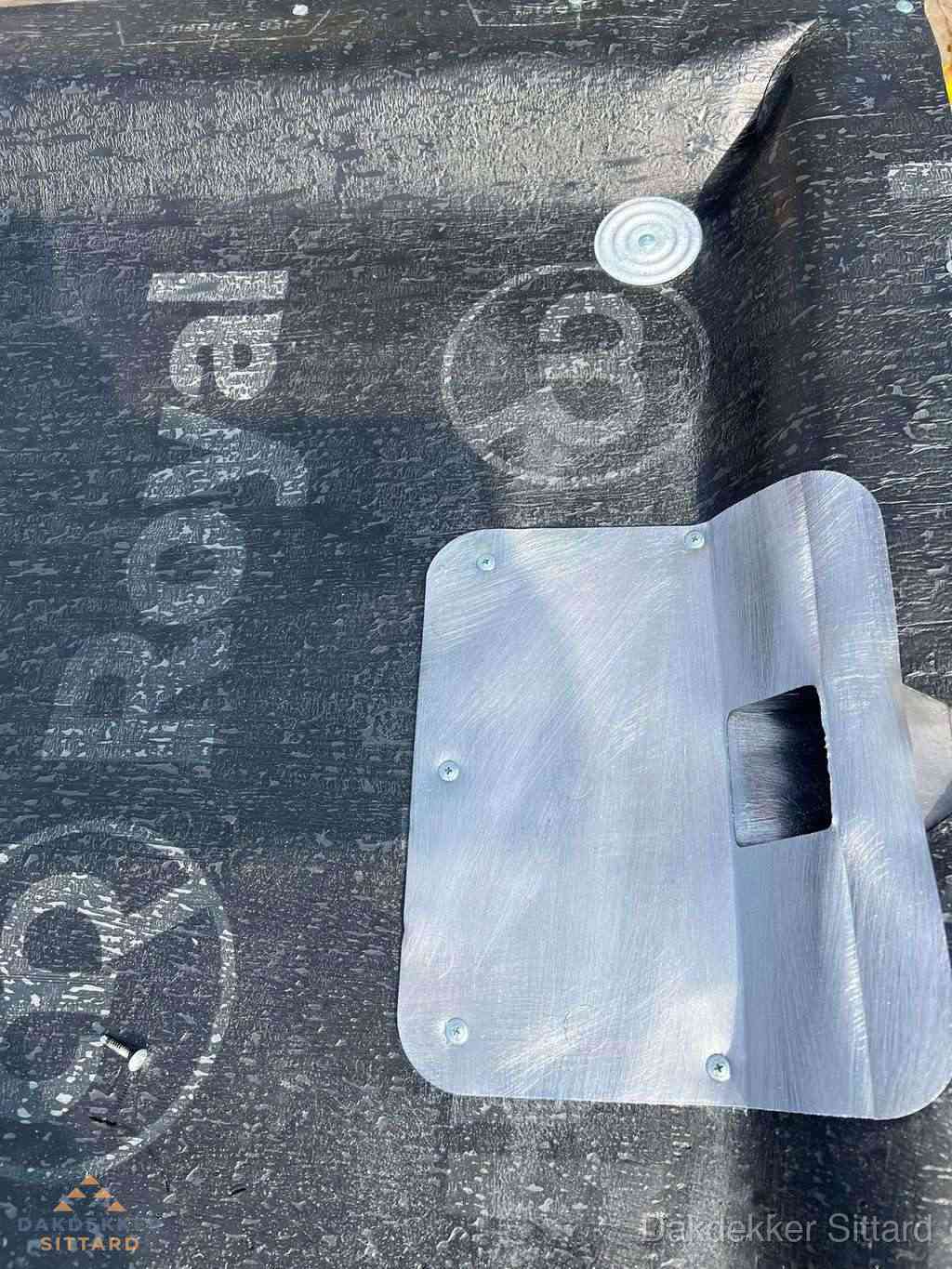 Dakdoorvoer met metalen afvoerplaat op bitumen dak in Sittard