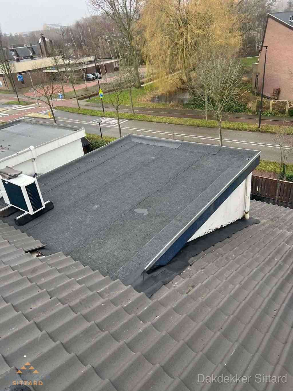 Plat dak met bitumen dakbedekking naast schuin pannendak in Sittard