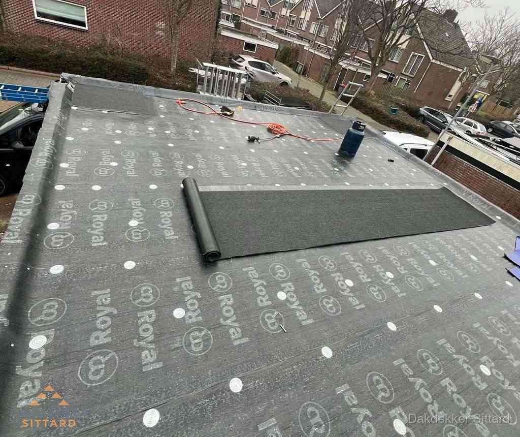 Dakdekker aan het werk met gasbrander op plat bitumen dak in Sittard