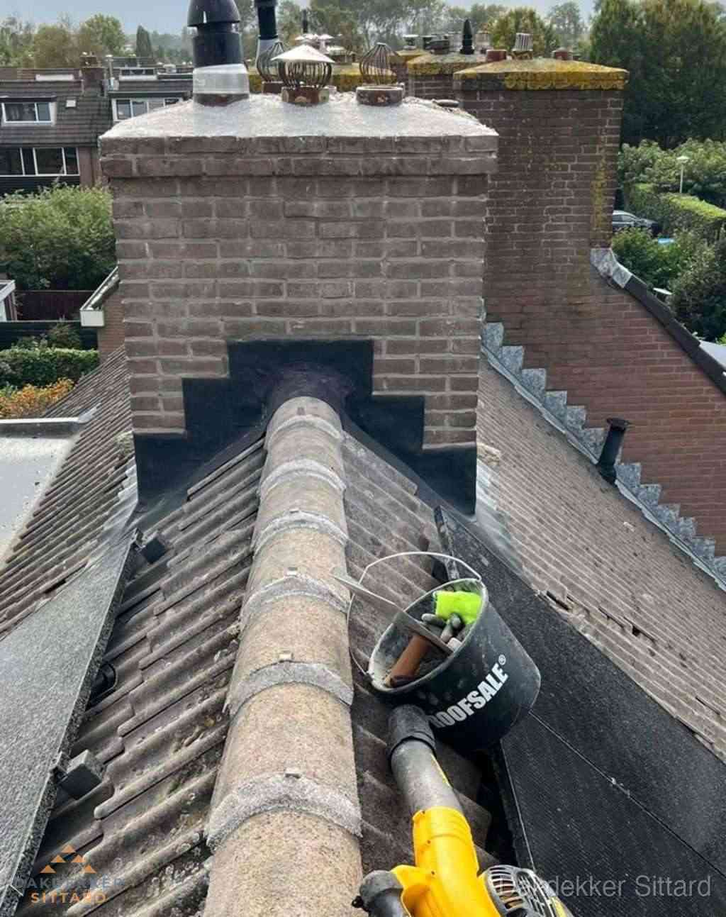 Dakdekker repareert bitumen dakleer bij dakdoorvoer in Sittard